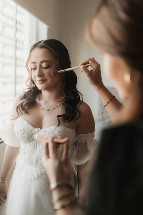 makeup artist doing makeup on bride