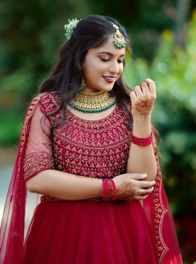 reception look in red lehenga and green accessories